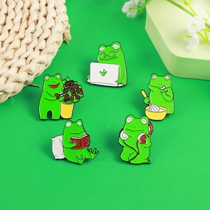 Lot de cinq pin's en émail grenouille verte montrant des activités comme lire et cuisiner