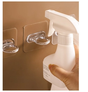 Strong adhesive wall hook holder for spray bottles on a smooth brown wall surface