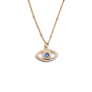Close-up of gold-plated eye pendant necklace with clear zircons and blue stone