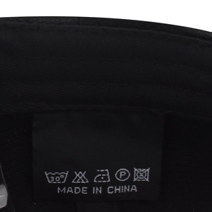 Detail view of the durable black camo baseball cap inner lining with wash care label