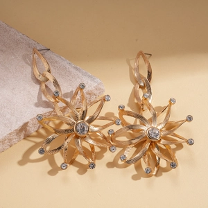 Close-up of golden sunflower chain earrings with sparkling rhinestones and metal hoops