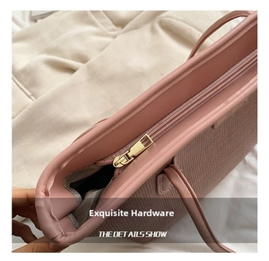 Detail showing the pink woven tote bag with premium golden metal zipper and light lining