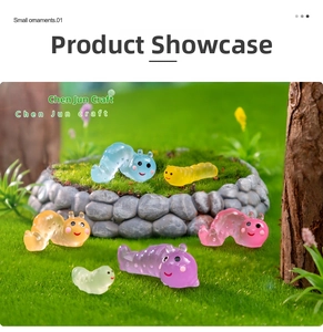 Detailed macro shot of six colorful translucent resin caterpillar figurines in a moss landscape