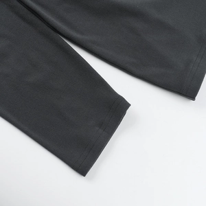 Détail des coutures fines et de la texture du tricot sur une robe grise à manches longues