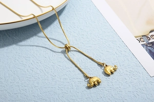 Detail of adjustable gold snake chain featuring dual 3D elephant charms on blue texture