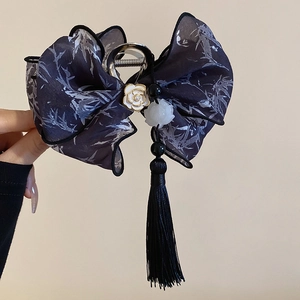 Detail of silk bow hair claw with bamboo leaf print, white camellia, and black tassels