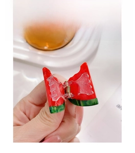 Detailansicht der Haarspange in Wassermelonenform aus Acetat mit goldener Metallfeder