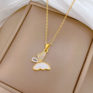 Macro shot of gold butterfly pendant with shell wing and zircon stones on gift box