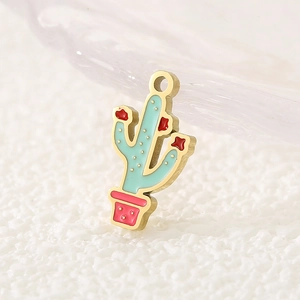 Macro shot of an enamel cactus pendant with gold edges, green body and pink flower pot