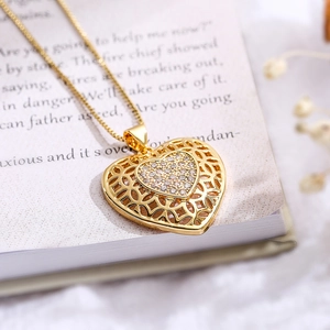 Minimalist hollow heart necklace with sparkling zircon pendant on vintage book background