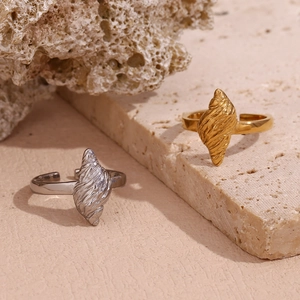 Detail of 18K gold and silver seashell rings on natural coral and stone background