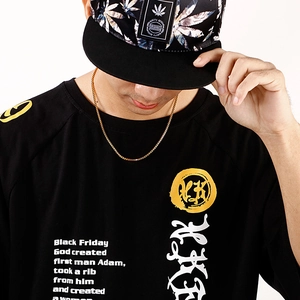 Close-up of black streetwear t-shirt featuring artistic typography and a round logo