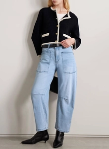 Detailed view of high-waist washed straight jeans with a contrast knit cardigan outfit