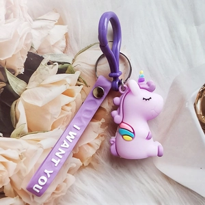 Close-up of a cute purple unicorn keychain with rainbow wings and I WANT YOU hand strap