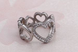 Macro shot of a silver heart-shaped hollow ring with sparkling small cubic zirconia stones
