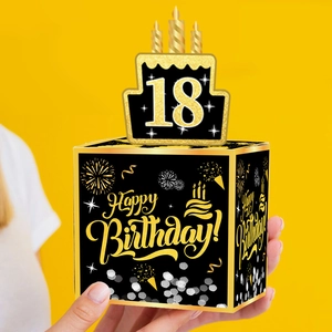 Detalle de caja de regalo para 18 cumpleaños en negro y dorado con adorno de tarta