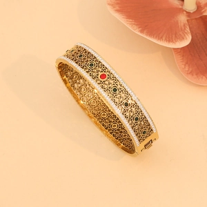 Detail of gold hollow-out tree of life bangle with colorful floral enamel and crystals
