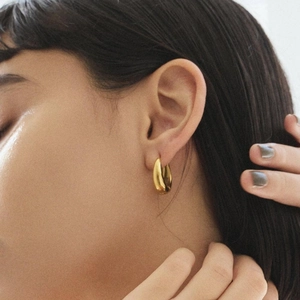 Polished 18k gold plated stainless steel chunky hoop earrings worn by a female model