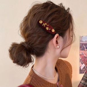 Vintage red velvet hair clip with golden zodiac horse and star charms worn in hair