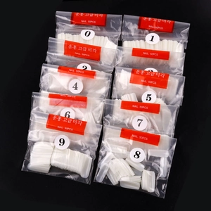 Detailed set of 500 clear coffin nail tips organized in bags numbered 0 to 9 on black backdrop