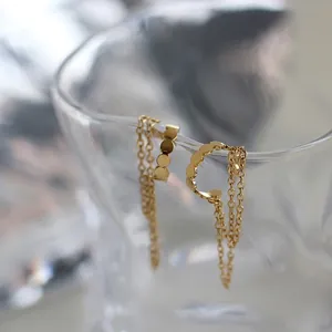 Macro detail of gold-plated titanium steel clip-on earrings with tassel chain fringe