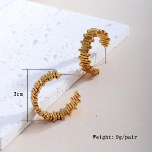 Makro-Detail von goldenen C-förmigen strukturierten Ohrringen, 3cm, 9g pro Paar