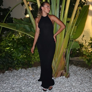 Detail of a black halter maxi dress with white piping and textured knit fabric detail
