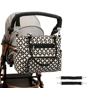 Detail of geometric pattern diaper bag hanging on stroller handle with hooks