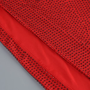 Detailed close-up of sparkling red rhinestones on the elegant evening dress fabric