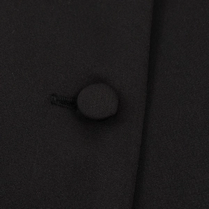 Elegant black peplum blazer with covered button detail and textured fabric close-up