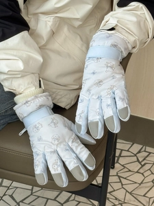 Detail of blue ski gloves with rabbit print, reinforced fingertips and velcro strap