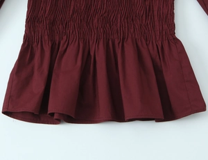 Détail du tissu bordeaux à texture nid d'abeille avec taille froncée élastique