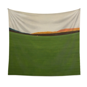 Detail of minimalist landscape tapestry featuring green lawn and mountain art on a white wall