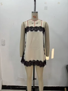 Détail de la dentelle florale noire sur un caraco en satin de couleur crème