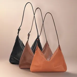 Three leather shoulder bags in black, coffee, and orange red showing soft pebble texture