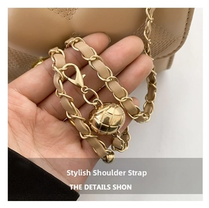 Detailed view of beige woven chain strap with adjustable gold quilted ball buckle