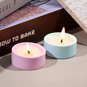 Primer plano de velas aromáticas rosa y azul en frascos de yeso mate para decorar el hogar