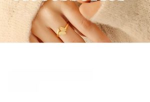 Close-up detail of golden butterfly ring with matte finish wings and a small white stone