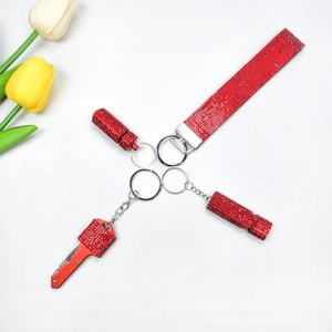 Detail shot of red rhinestone keychain set with folding knife, wristlet and accessories