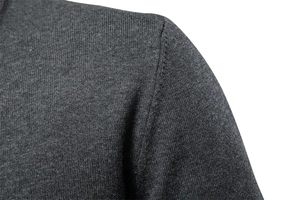 Macro view of dark grey knit sweater showing shoulder seam and fine texture detail