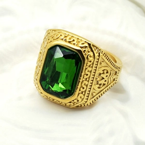 Detailed close-up of a vintage men's gold ring with a large rectangular green gemstone