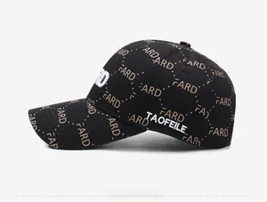 Detail view of black baseball cap featuring brown monogram pattern and white side embroidery
