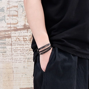 Men's multilayered black leather bracelet with braided rope and matte beads on wrist