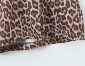 Detailed view of leopard print fabric with precise double-needle stitching on the hem