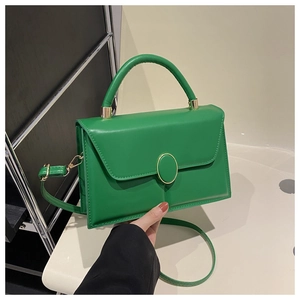 Détail du sac à main en similicuir vert émeraude avec couture et fermoir doré ovale
