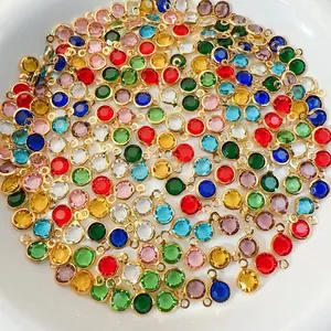 Close-up of colorful faceted glass charms with gold metal frames for jewelry making