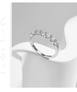 Macro shot of silver ring featuring seven round cut diamonds in a classic claw setting