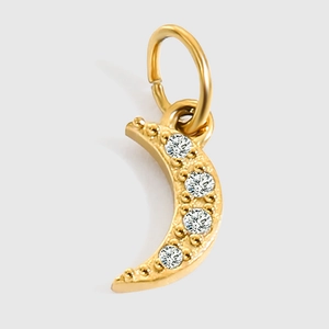 Macro shot of gold crescent moon pendant featuring four inlaid round clear zircon stones