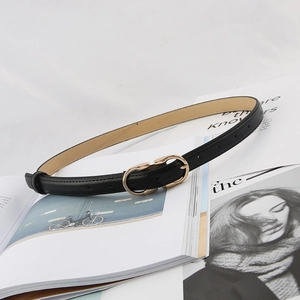 Minimalist black leather belt for women with golden double ring buckle on a magazine