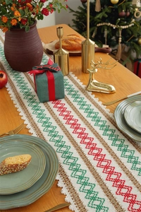 Detailed embroidery on linen table runner featuring Christmas geometric patterns and lace edge